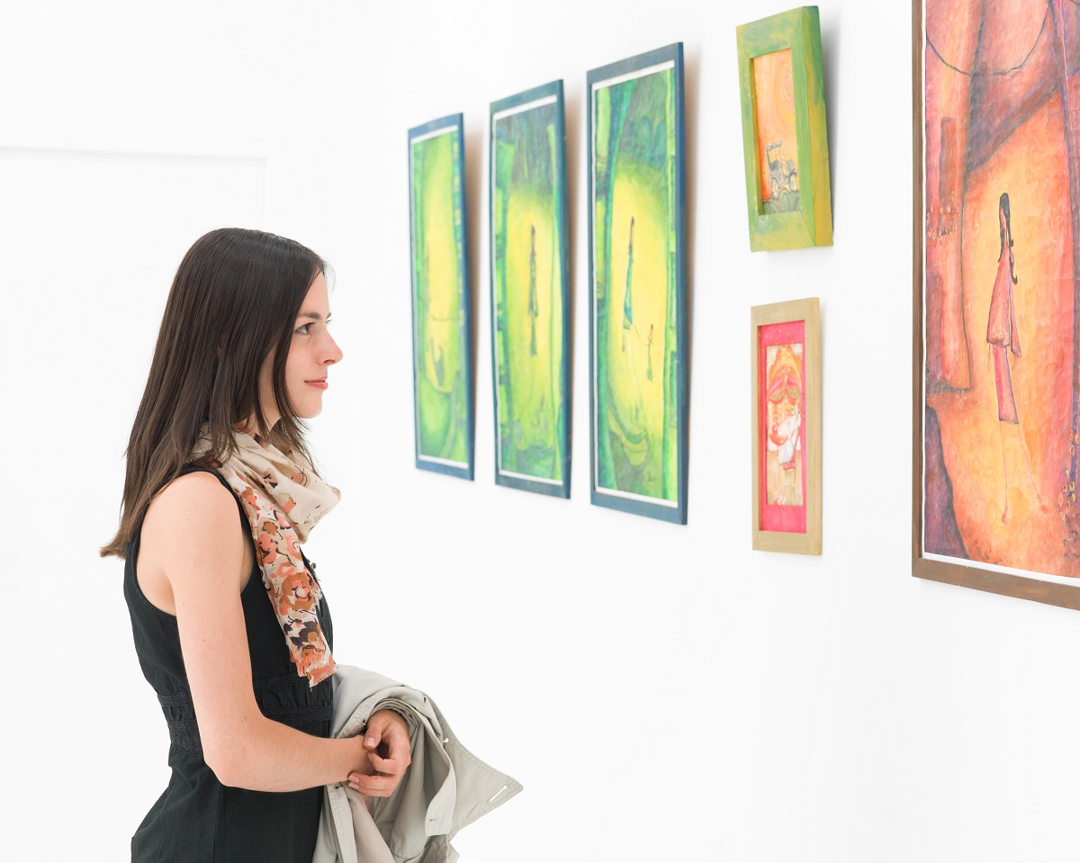 girl standing in front of a painting