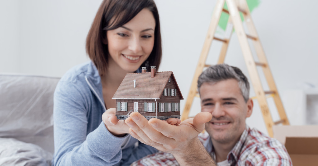 man and woman holding a mini home