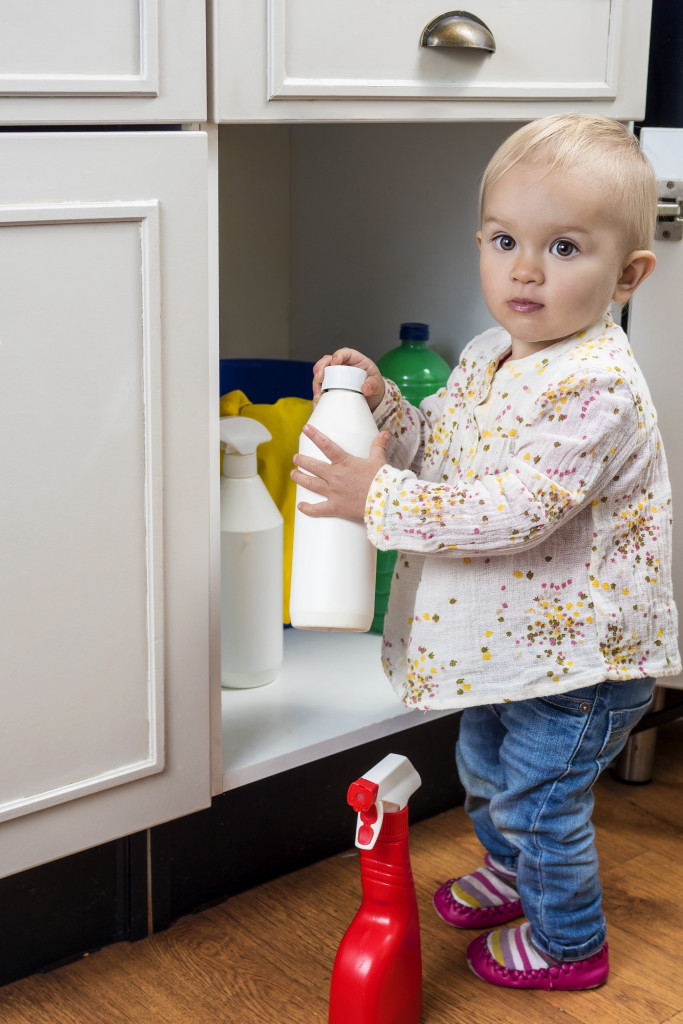 child holding cleaning products