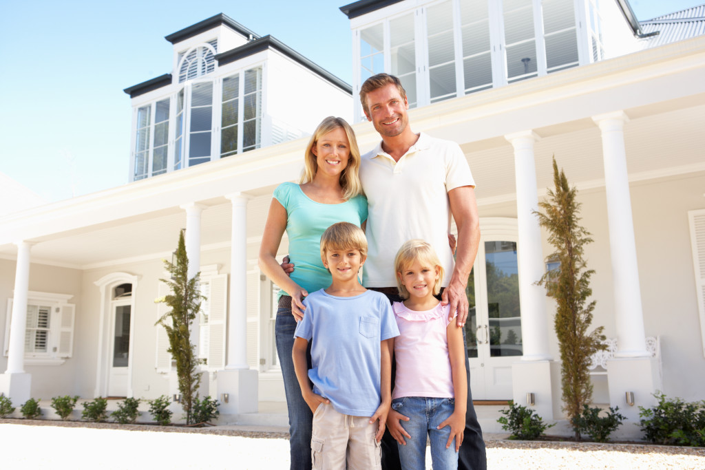 family standing next to dream home