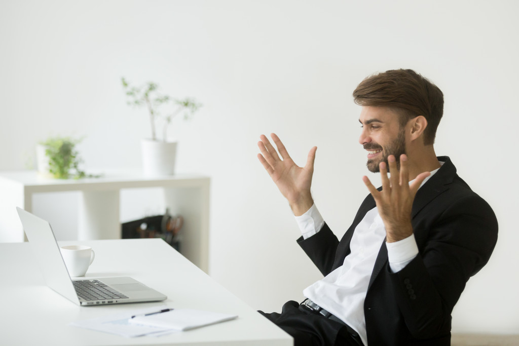 man smiling at his laptop