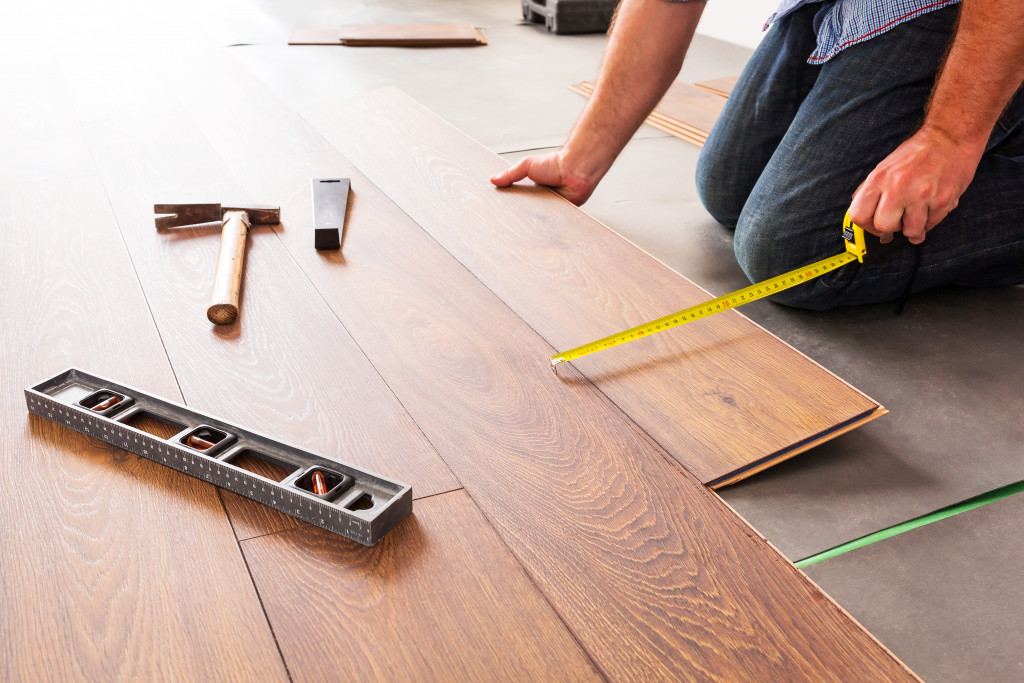 man installing wooden floor boards