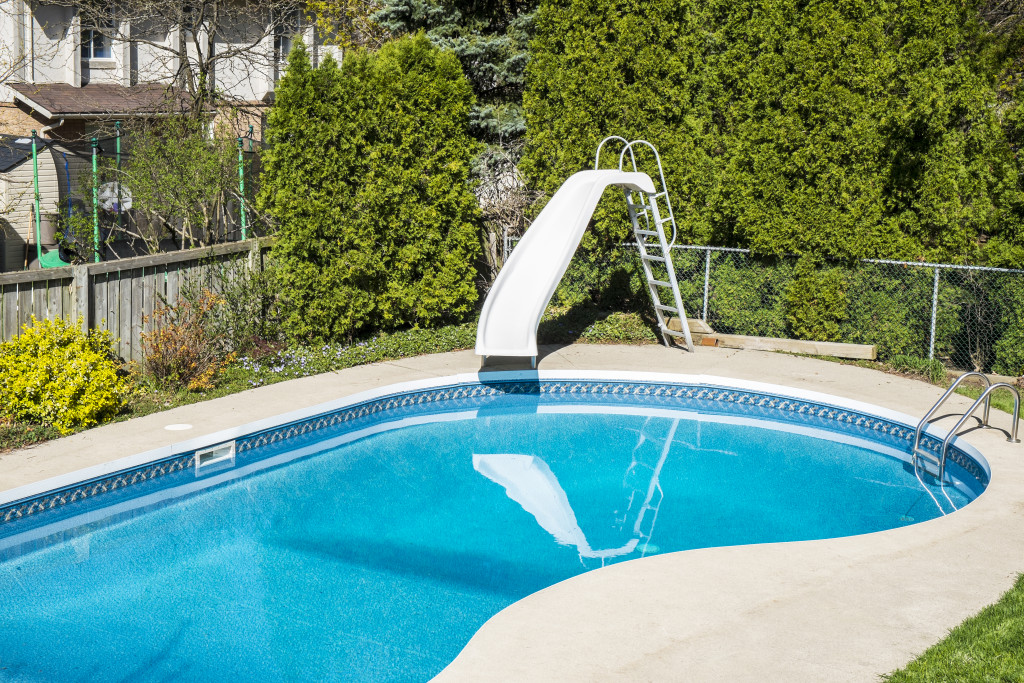 Beautiful home backyard with swimming pool and slide 