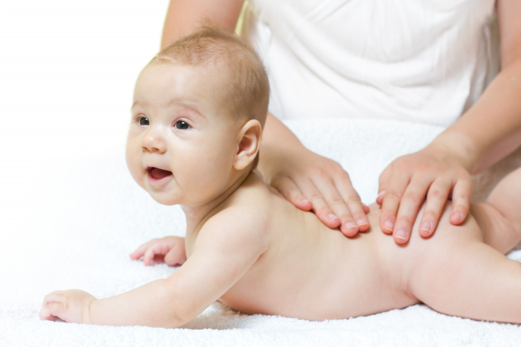 a mother caring for baby skin by massaging