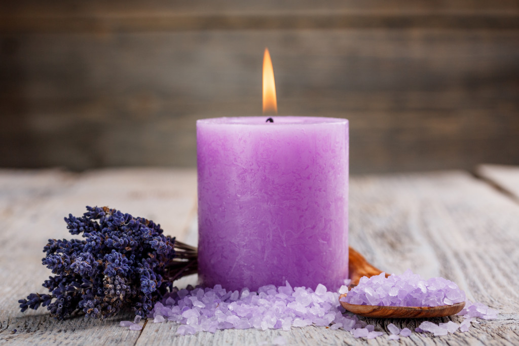 lit purple spa candle with lavender flower and purple salts