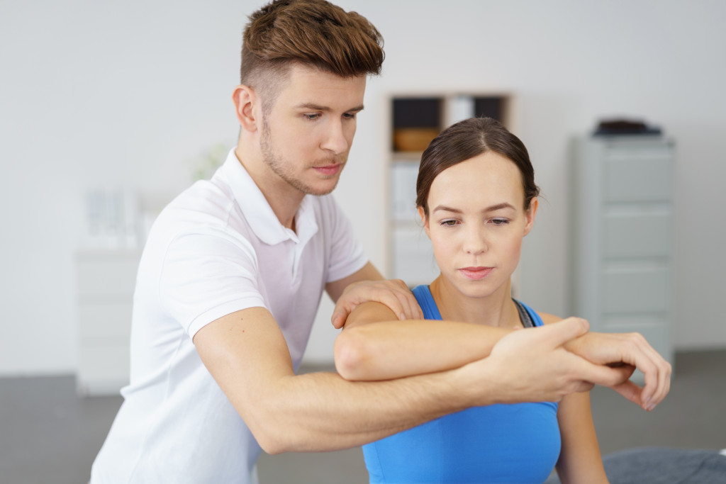 therapist assisting a patient in the arm