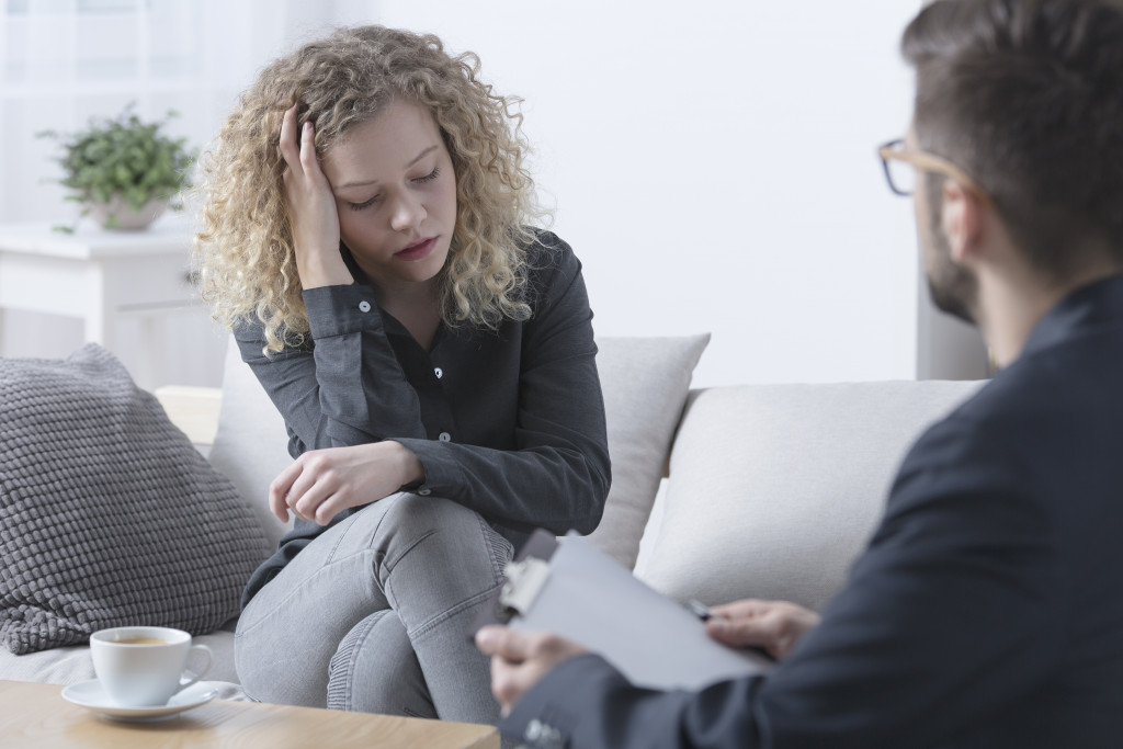 Young woman talking to a therapist at a clinic.