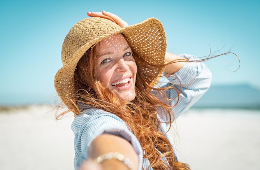 A woman out enjoying the sun while wearing a weaved straw hat