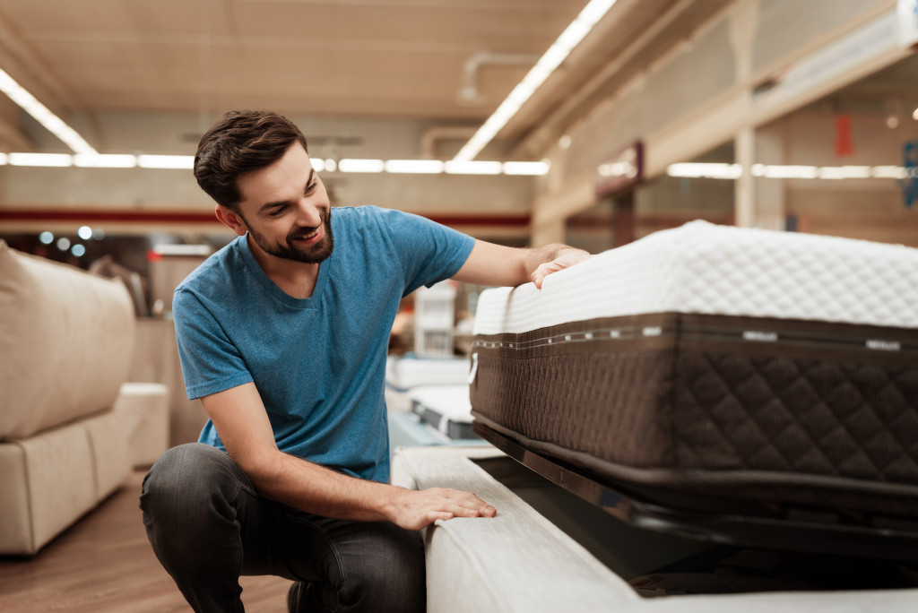 A man looking at a mattress in a store