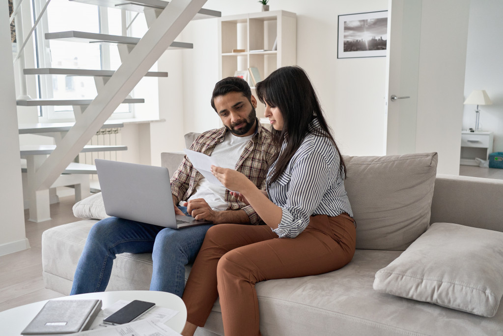 A couple looking at papers and a laptop at home