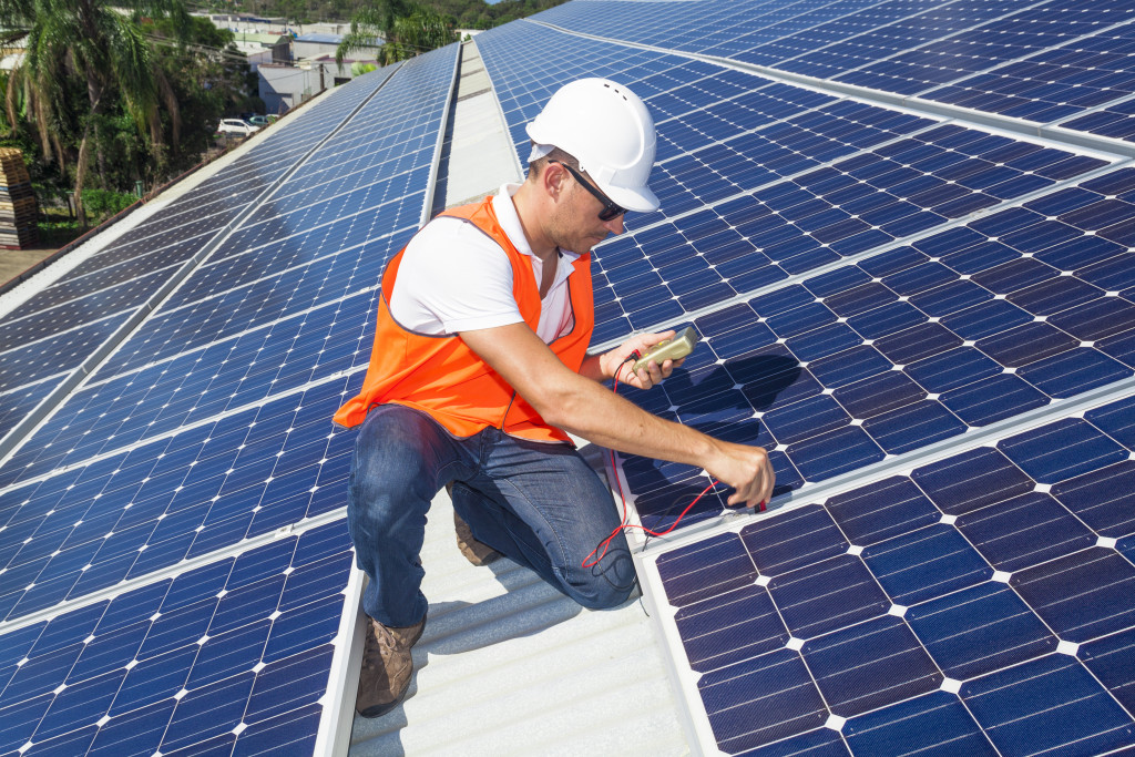 Technician checking solar panels installed on a roof.