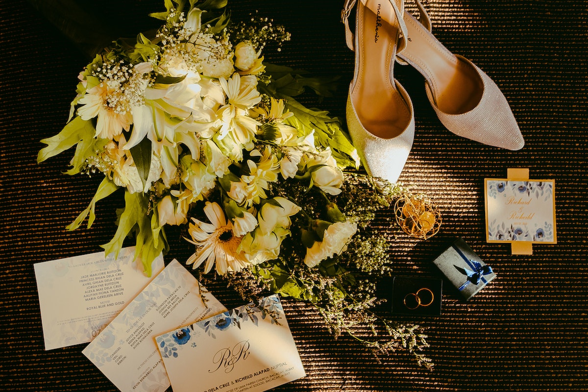 Pair Of Beige Shoes Beside Bouquet