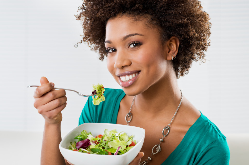 A woman eating a salad bowl